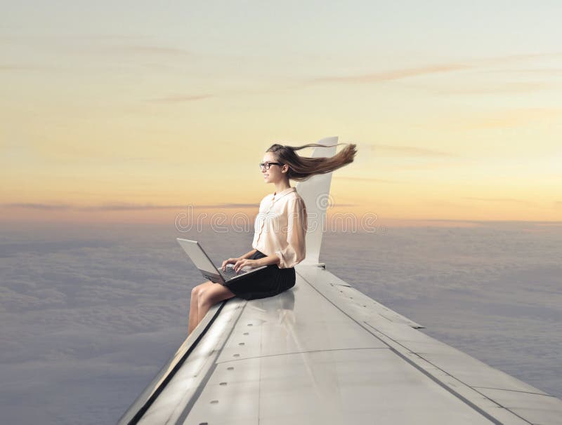 woman-sitting-plane-wing-using-laptop-35811752.jpg